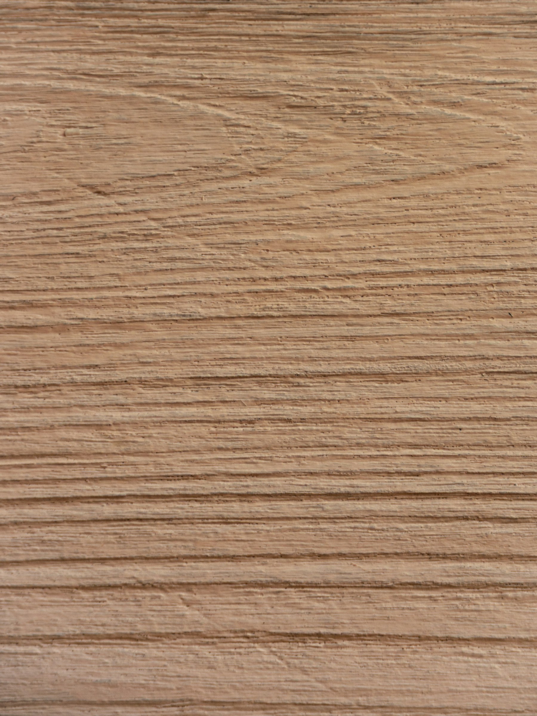 An extreme close-up of natural light-oak wood grain, showing fine parallel grain lines and subtle surface texture on a finished timber surface