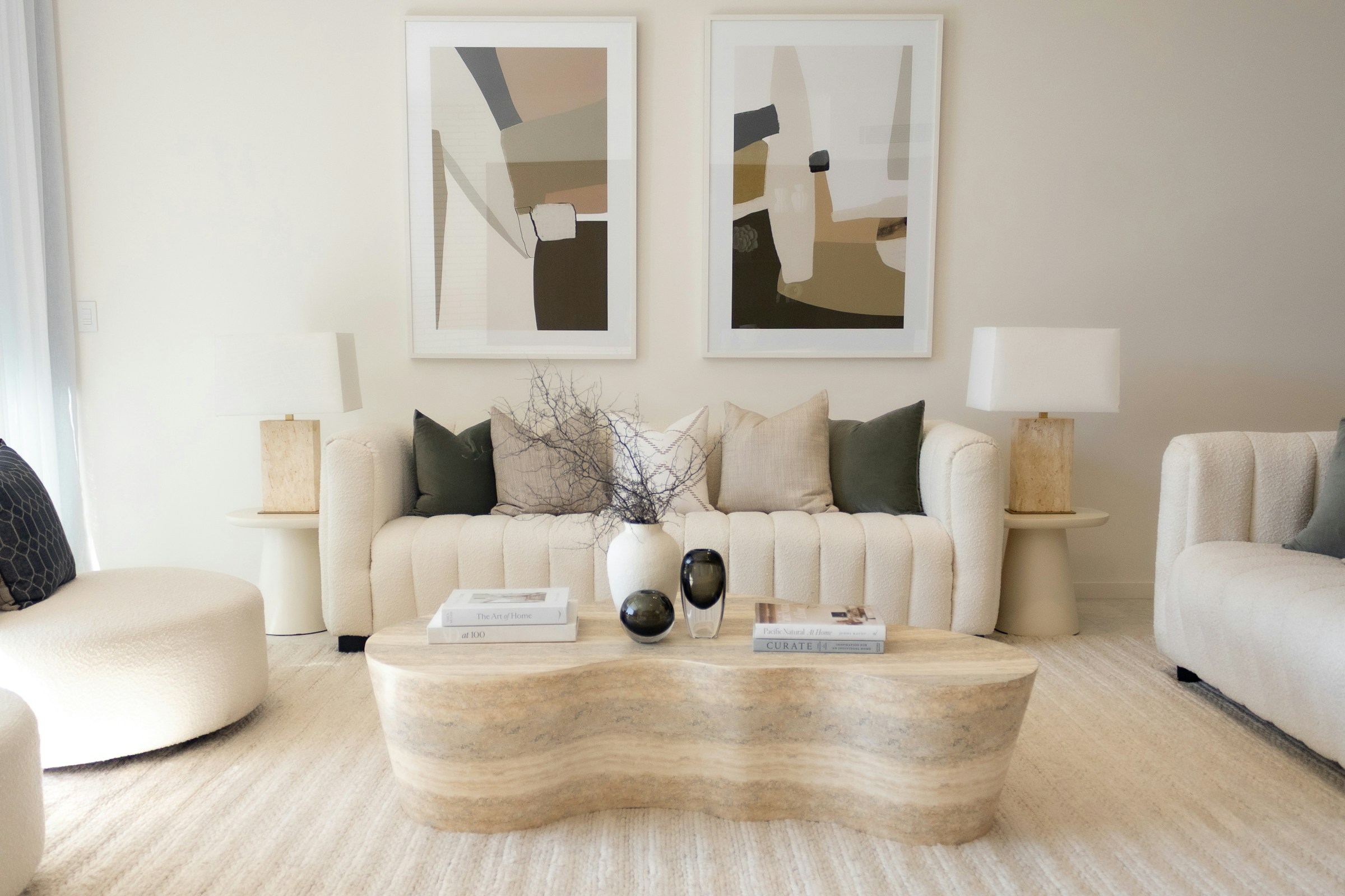 A tranquil living room with natural stone fireplace, bespoke oak built-ins, and neutral linen furnishings bathed in soft daylight